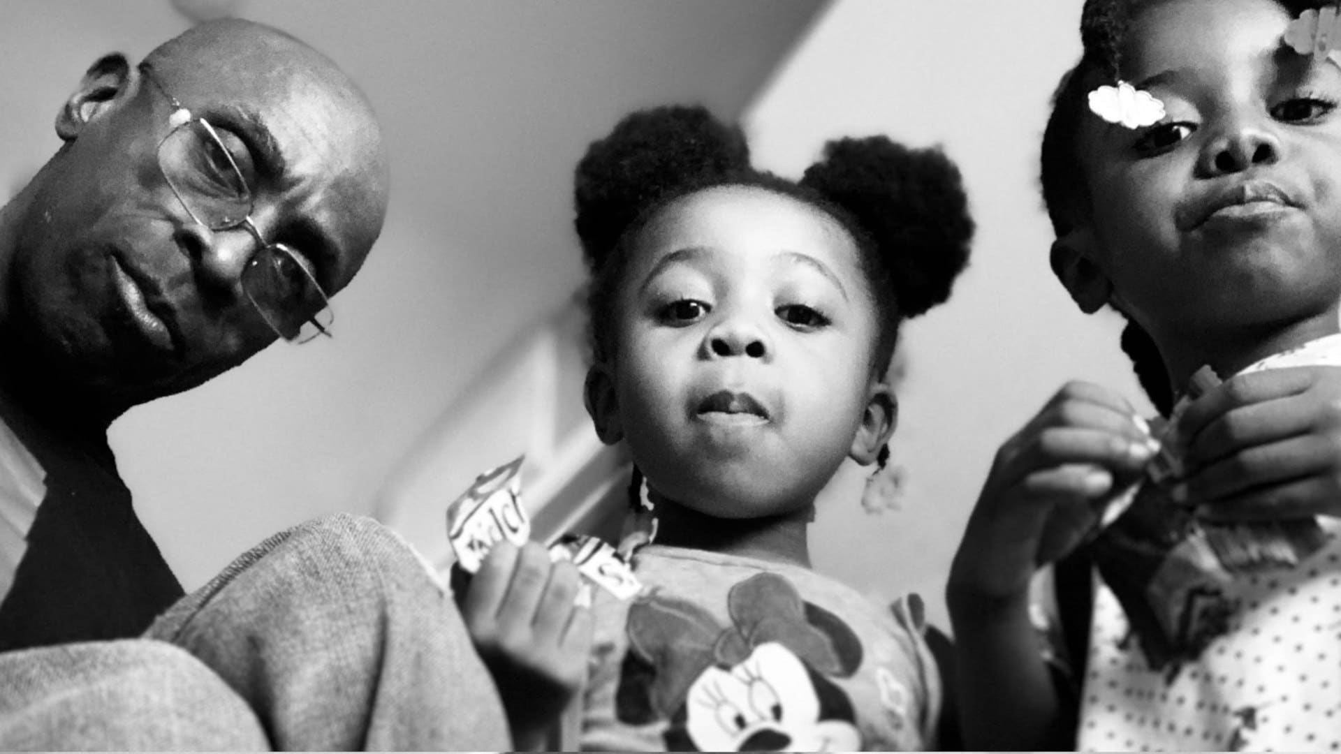 Keith Jones and his twin daughters. The girls are each holding a package of snacks.